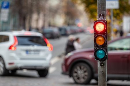 a city crossing with a semaphore on blurred background with cars in the evening streets, red lightの写真素材