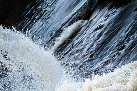 close-up of flowing water, rapid water splashes of an white water river or stream, bubbly water