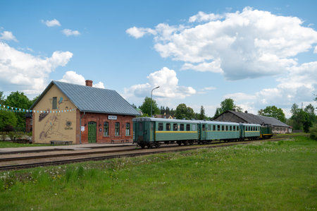 Aluksne, Latvia - May 24. 2023: Aluksne train station with narrow gauge train in front.のeditorial素材