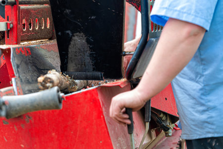 A man chops firewood with a wood chipper, selective focus