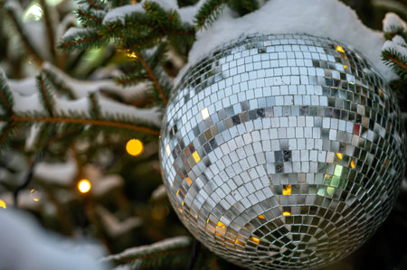 Mirrored shiny silver disco ball and Golden Christmas balls decorate on Christmas tree with bokeh