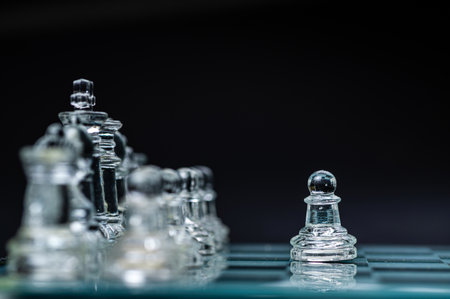 transparent glass chess on dark background, selective focus on pawn piece, close-up