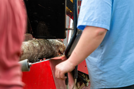 A man chops firewood with a wood chipper, selective focus