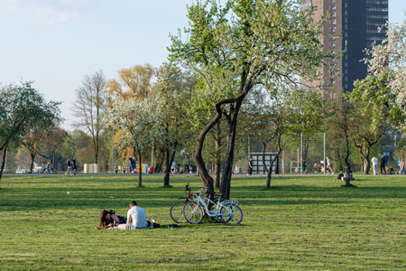 Riga, Latvia - May 12, 2021: People are relaxing in theLucavsala  park, sitting on the grass and enjoying the warm spring daysのeditorial素材
