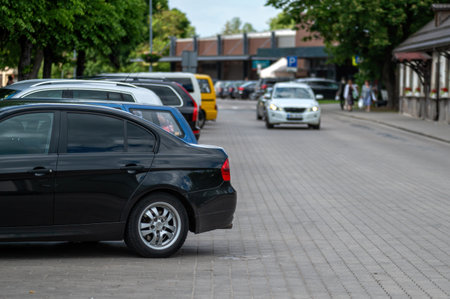 A black car parked on a city street with other cars. Shallow depth of feldの写真素材