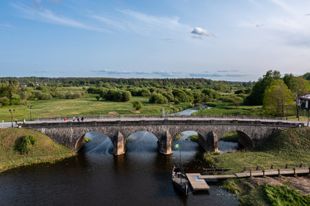 Stone bridge crossing river with flowing water underneath. Kandava, Latvia
