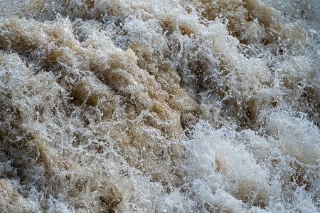 close-up of flowing water, rapid water splashes of an white water river or stream, bubbly waterの写真素材