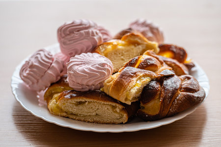 A plate holds baked goods and sweet treats in a warm, inviting bakery.の写真素材