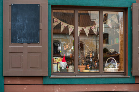 A welcoming shop window displays handmade crafts and seasonal decorations.の写真素材