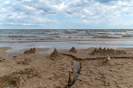 Kids enjoy creating sandy structures by the water's edge.の写真素材
