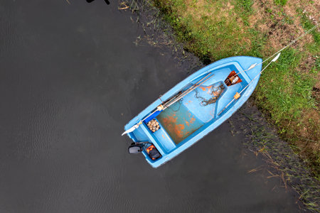 A small blue boat rests quietly by the riverbank, suggesting a day of fishing.