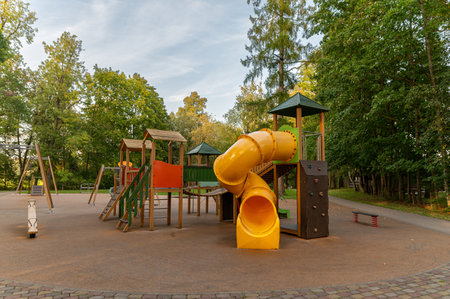 Colorful playground equipment including a slide and climbing features surrounded by trees.の写真素材