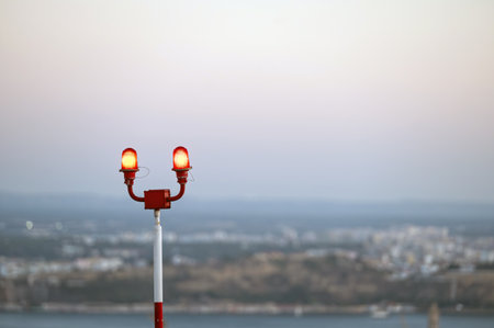Dusk settles as airfield warning lights illuminate the quiet coastal area near the city.の写真素材