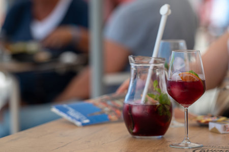 Enjoying colorful drinks with friends at an outdoor cafe on a sunny day.の写真素材