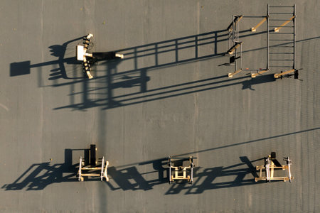 Equipment displays dramatic shadows on a flat area in the warm light of dusk.の写真素材