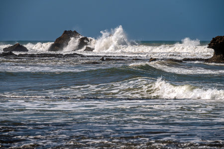 Powerful waves break on rocky shore, creating a dramatic view of Essaouira
