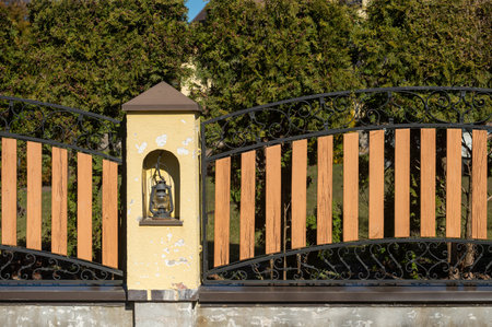 Decorative gate features wooden slats and ornate metalwork accented by a vintage lanternの写真素材