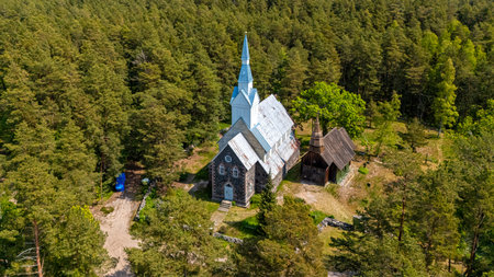 Explore the tranquil setting of a historic church surrounded by dense forest on Ruhnu Island.の写真素材