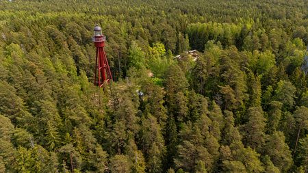 The lighthouse rises among lush greenery on Estonia's Ruhnu Island, showcasing beauty.の写真素材
