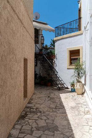 Stone pathway leads to an inviting staircase among buildings in Crete, Greece on sunny day.の写真素材