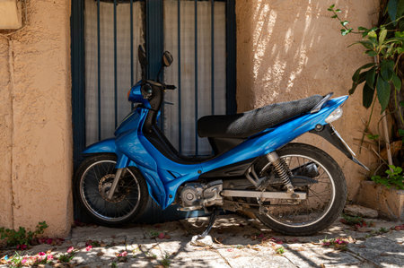 A bright blue scooter rests against a wall in Crete, Greece, showcasing local color and charm.の写真素材