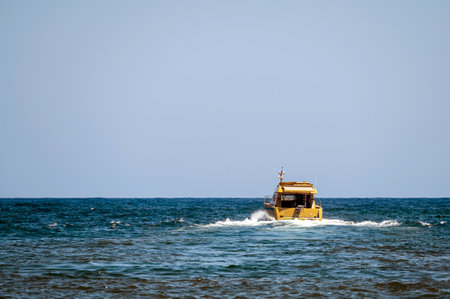 A boat cruising through the turquoise waters near Chania, Crete under a blue sky.の写真素材