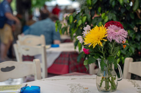Brightly colored flowers decorate a cafe table, creating a cheerful atmosphere in Crete.