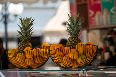 Two baskets of ripe oranges and pineapples showcase the local harvest in Crete.の写真素材