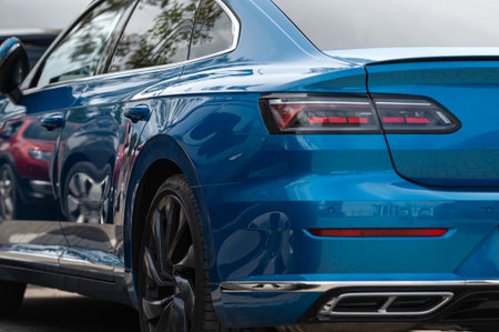 Blue sedan remains parked in a bustling city environment, highlighting its modern features.