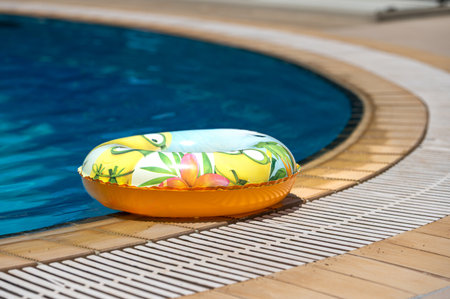 A colorful pool float rests beside crystal clear water in a sunny setting on Crete.