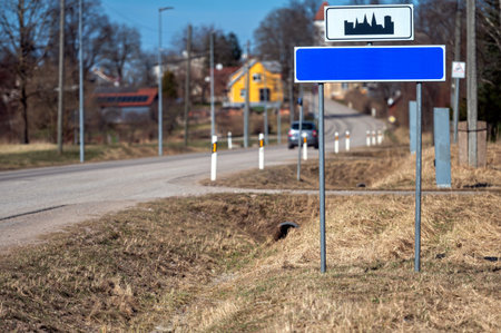 Blank road sign mock-up placed beside a quiet country road on a sunny dayの写真素材