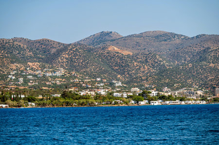 Vibrant coastline of Crete reveals lush mountains along the serene sea on a sunny day.の写真素材