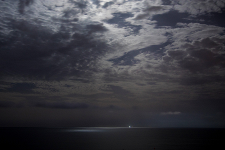 Night sky with moonlight clouds and seaの写真素材