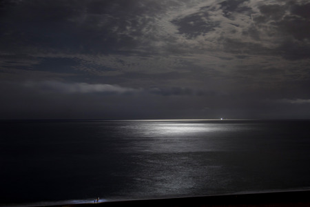 Night sky with moonlight clouds and seaの写真素材