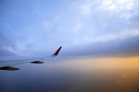 View of window at flying airplane and sky with clouds from top view.