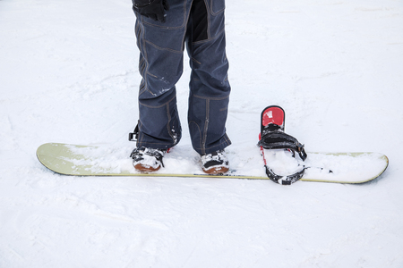 Legs athlete in an snowboard on snow on a sunny day. The concept of winter sportsの写真素材
