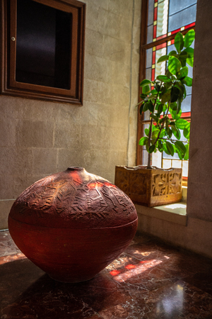 Red vase in a room near the windowの写真素材