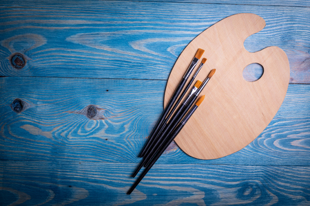 Palette and brushes on a wooden old blue backgroundの写真素材