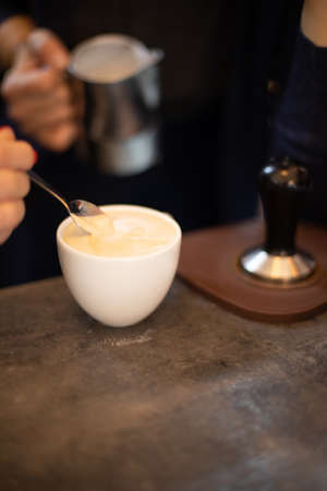 The hands of a barista brew cappuccino coffeeの写真素材