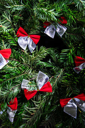Background of christmas tree wreath with red bowsの写真素材