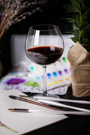 Cozy still life with wine and watercolor paintsの写真素材