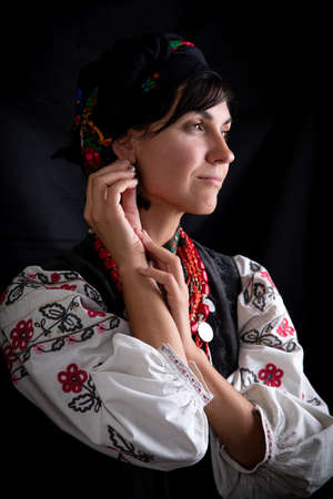 A beautiful Ukrainian woman in traditional clothes on dark background
