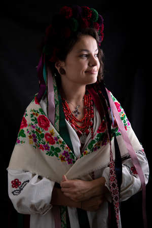 A beautiful Ukrainian woman in traditional clothes on dark background