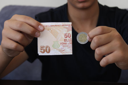50 Turkish lira and 2 euro on black background. The worthlessness of the Turkish currency against...