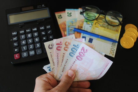 The paper currency of Turkey. Calculator in the background.Turkish lira banknotes. man counting...