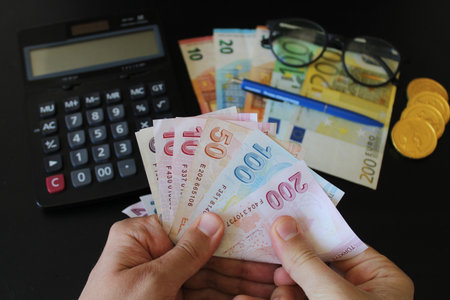 The paper currency of Turkey. Calculator in the background.Turkish lira banknotes. man counting...
