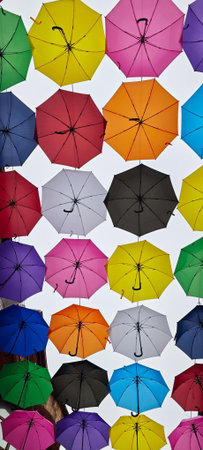 Colorful umbrellas hanging in the street.