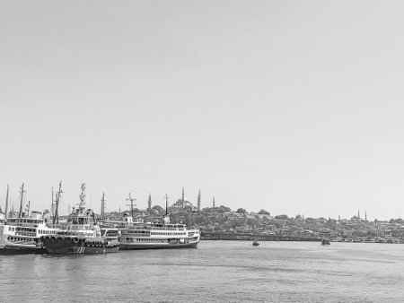 A ship with a red hull sits in the water. Istanbul City silhouette.の写真素材