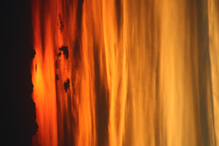 The sun setting behind the clouds. Orange sky. Amazing sunsetの写真素材