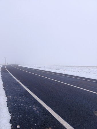 A highway with snow falling around it. Foggy and cold weather.の写真素材